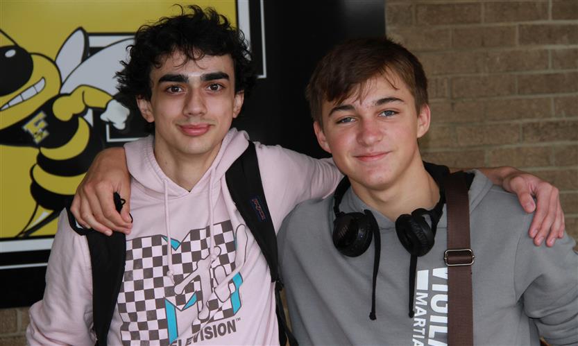 Two students smile